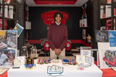 Jalen Blackwell standing behind a display table featuring his STEM kits.