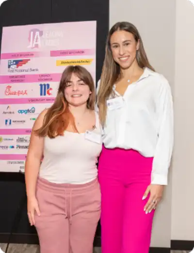 Female student and Female professional pose and smile looking at the camera