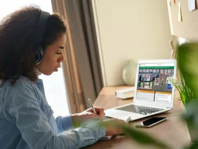 Female student entering JA Inspire on her laptop